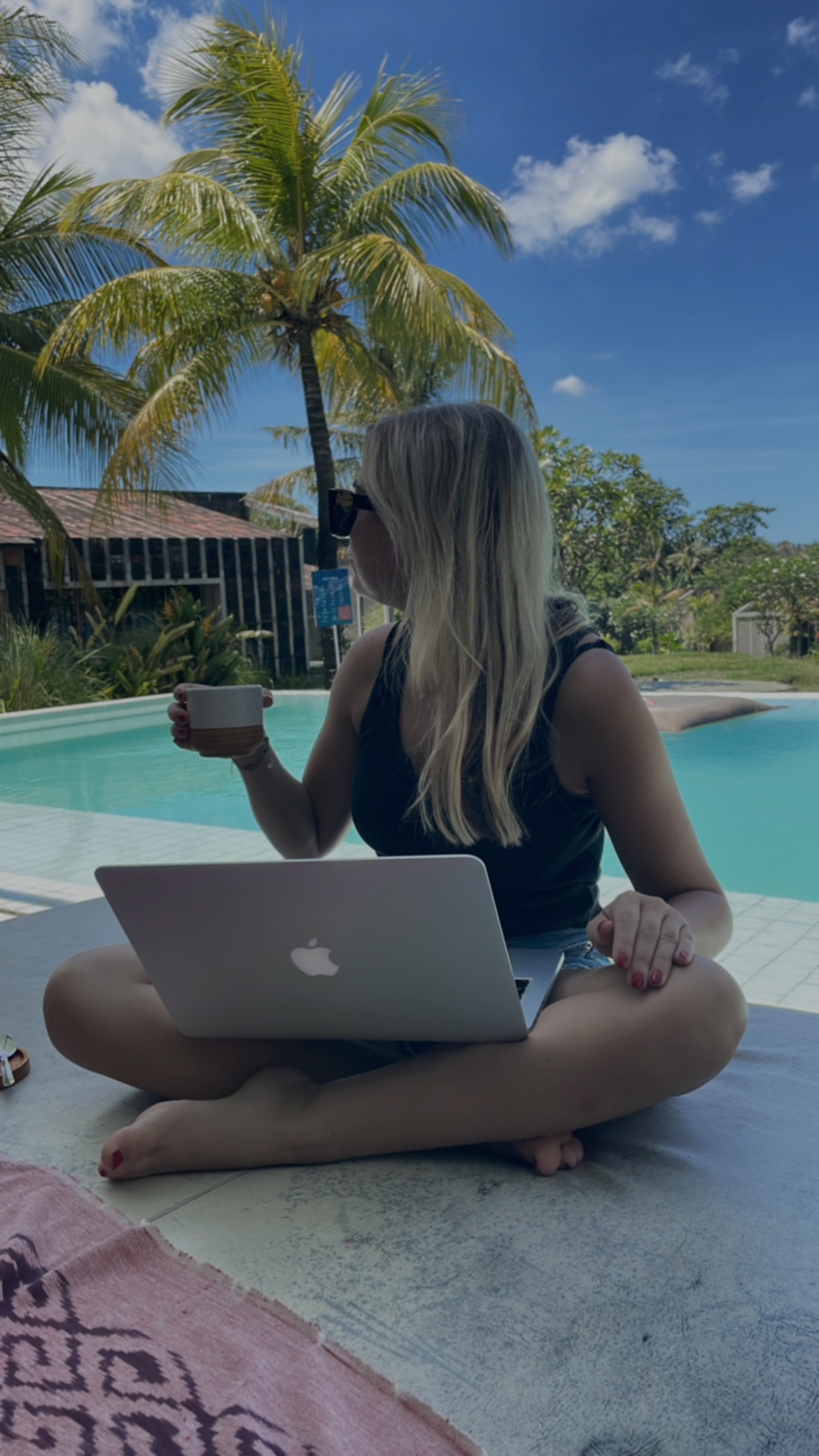 Remote werken bij het zwembad met laptop en koffie